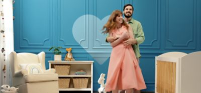 Couple dancing in front of a blue wall in a nursery.
