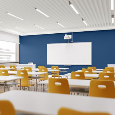 A bright classroom with a white board against a blue wall.