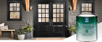 Double front doors painted black with vinyl siding and a window on each side with black painted fraims and a can of Emerald Exterior paint.