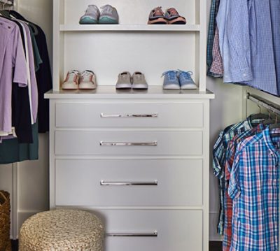 Built-in closet storage with easy-pull handles and clothing racks at sitting level.