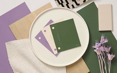 Flat lay image featuring paint samples of the green, white, and light purple colors Dabito used in his home, alongside a variety of materials swatches. 