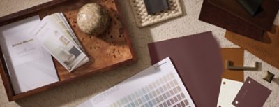 Flatlay of various Sherwin-Williams designer color tools, materials, and samples arrayed on a surface.