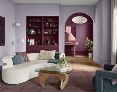 Living area with built in shelves, white couch, coffee table, and the walls painted in Grape Mist SW 6548.