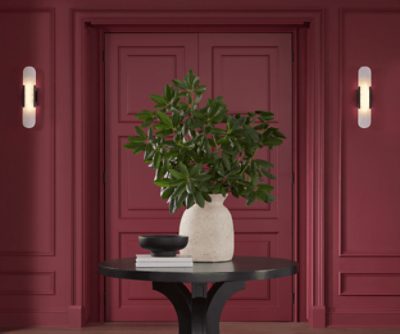 Walls painted in SW 7578 Borscht, double doors with circular table with a plant on top.