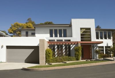 A modern style home with white paint and a wooden door and walkway. S-W colors featured: SW 7006, SW 7746, SW 7702