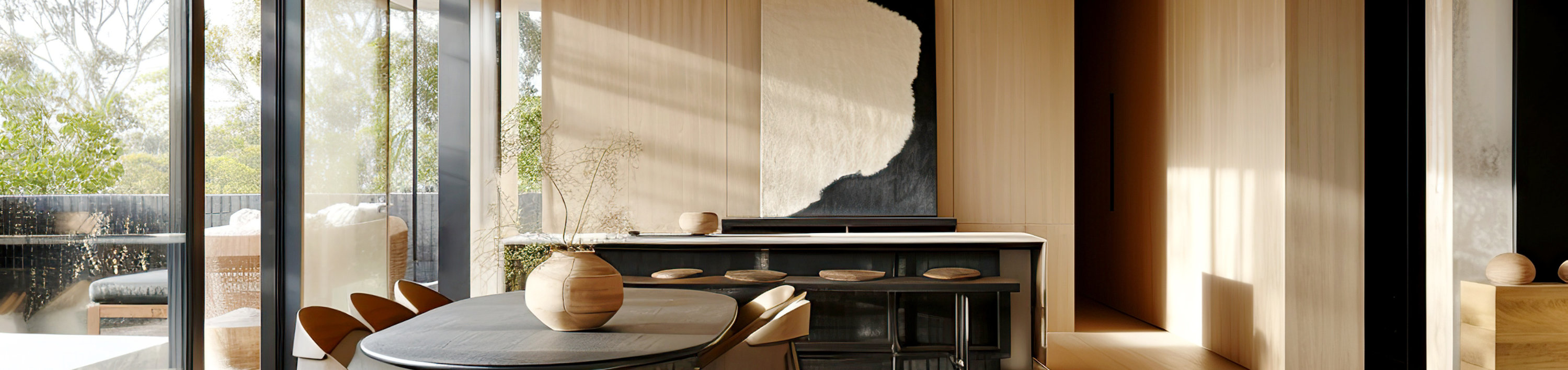 Modern living and dining area with neutral tones, round table, sofa, and large windows.