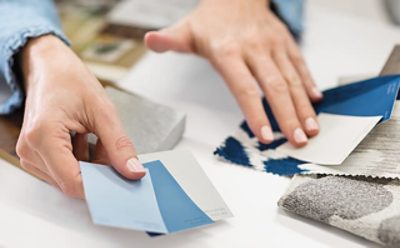 Un contratista sosteniendo tarjetas de muestra de pintura decidiendo qué color usar.