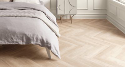 A bedroom with wood floors and white wainscotting.