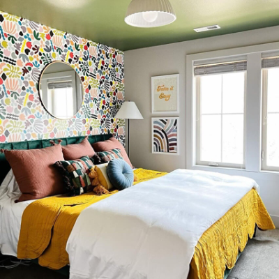 A multicolor bedroom with bright wallpaper.