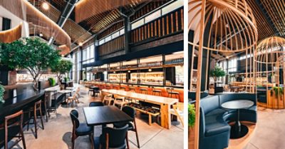 More views of spacious food hall interior with variety of seating and gathering areas, trees and greenery, and booths enclosed in framed wooden structures resembling large bird cages