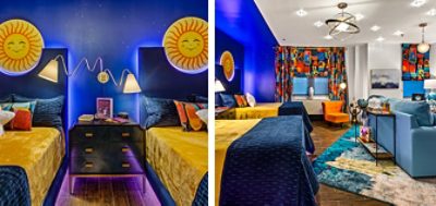 Guestroom in Ronald McDonald House with dark blue walls, funky furnishings, bold patterned curtains and celestial accents like large smiling sun faces above the headboards and star-shaped throw pillows.