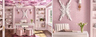 A pastel pink home office with a white fluted desk, pink stools, and bookshelves. A floral wallpapered ceiling and a white starburst wall sculpture add decorative detail.