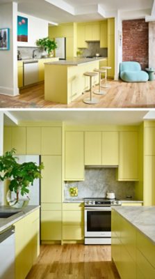 Modern kitchen with Chartreuse cabinets, stone countertops, modern art, and a plush light-blue chair by an exposed brick wall.