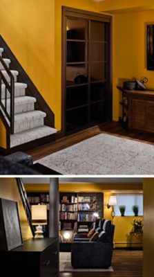 Basement interior featuring Goldenrod yellow walls, carpeted stairs, a cozy sitting area with built-in bookshelves, and cushioned chairs.