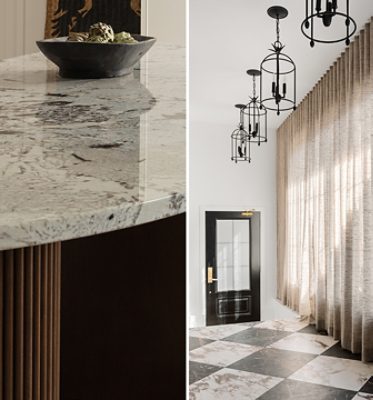 Close-up of the curved kitchen island countertop with a bowl and a room with lantern-style pendant lights, floor-to-ceiling curtains, and marble tile flooring bathed in natural light. 