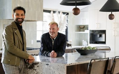 Designer Aly Velji and husband Jason Krell standing at the marble island in their newly renovated kitchen.