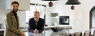 Designer Aly Velji and husband Jason Krell standing at the marble island in their newly renovated kitchen.