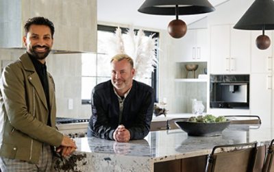 Designer Aly Velji and husband Jason Krell standing at the marble island in their newly renovated kitchen.