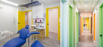 Interior of dental exam room and corridor with white walls and cheerfully bright multicolored doors and trim.