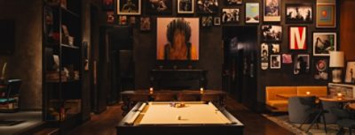 Stylish restaurant interior with a pool table, eclectic wall art, and cozy seating. 