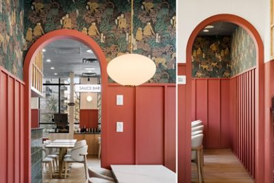 Interior with archways and molding painted in Sherwin-Williams Foxy, decorative wallpaper, white pendant light, and "SAUCE BAR" visible in the background. 