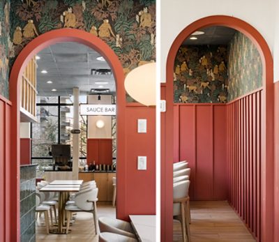 Interior with archways and molding painted in Sherwin-Williams Foxy, decorative wallpaper, white pendant light, and "SAUCE BAR" visible in the background. 