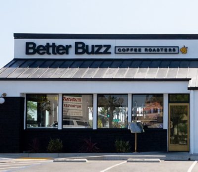 Exterior of the Better Buzz Coffee Roasters Oceanside location with signage and hexagonal designs. 