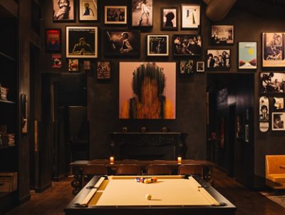 Stylish restaurant interior with a pool table, eclectic wall art, and cozy seating.