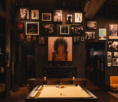 Stylish restaurant interior with a pool table, eclectic wall art, and cozy seating.