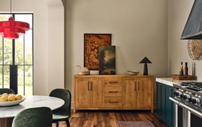 Modern open-concept kitchen with wooden sideboard, a marble-topped round table, Sherwin-Williams Cascades teal cabinets and sand-colored Beachcomber walls.