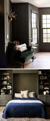 A stylish bedroom featuring a dark green chair with a white blanket, a small table with a flower, and a bed topped with a deep-blue quilt and flanked by built-in shelves.