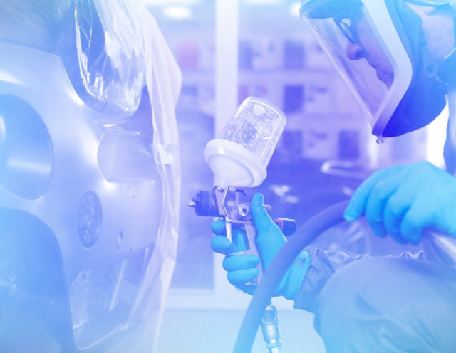 A painter spraying a bumper with Octoral paint