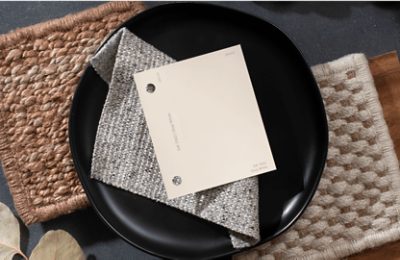 A light neutral color chip on top of a folded cloth napkin and black plate.