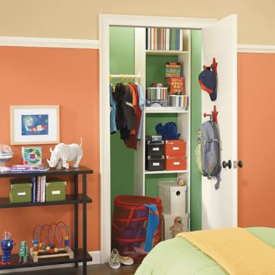 A child's bedroom painted two shades of orange with the closet door opened showing storage and closet walls painted green.