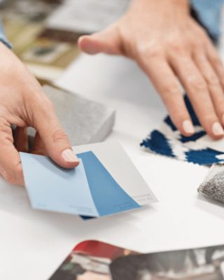 A person looking at color chips and other design elements.