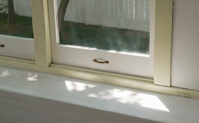 A window with cracked paint trim. 