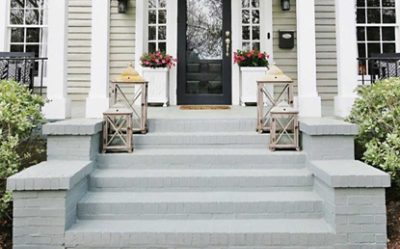 Bricks steps up to a front door painted gray.