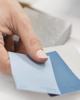 A person holding three color chips.