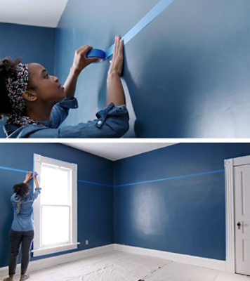 A woman using painters tape to paint.