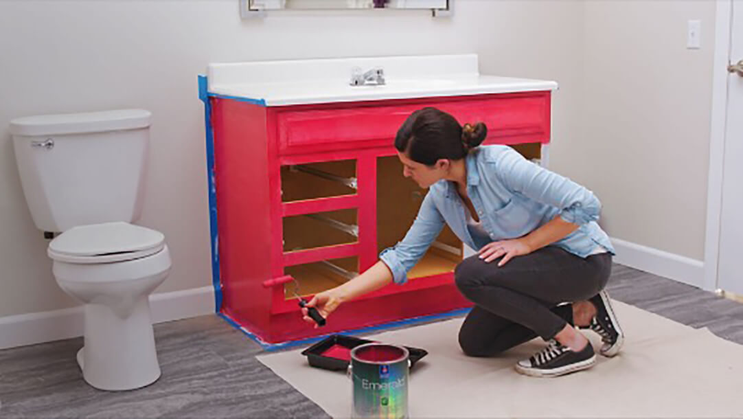 A woman is painting a bathroom vanity.
