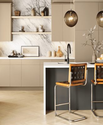 A kitchen with cream colored floors and cabinets with a white marble backsplash and an island.