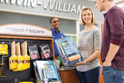 A Sherwin-Williams store associate assisting a couple in selecting a painting kit.