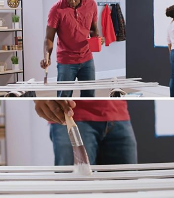 A man painting the trim used for a gallery wall frame