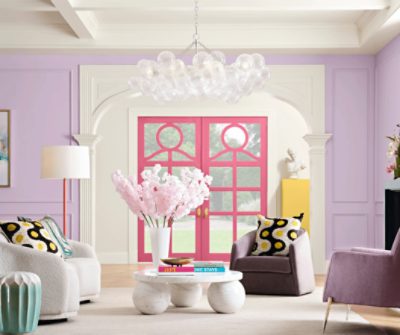 A sitting area with walls painted Euphoric Lilac SW6835 and door accent trim painted Dragon Fruit SW6855.