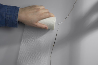 Person repairing a cracked wall.
