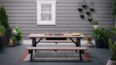 A picnic table with a drink trough in the center.