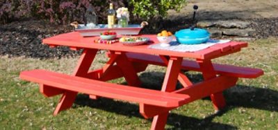A red painted outdoor picnic table with food and decor