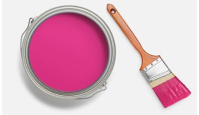 Open can of bright pink paint with a wooden-handled paintbrush dipped in the paint, ready for use.