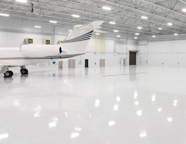 Plane in a hangar with a reflective resinous floor. 