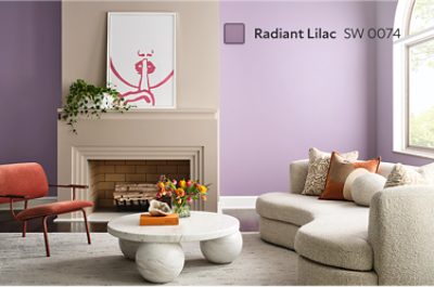 Living room painted Radiant Lilac with a large fireplace and a cream sofa.